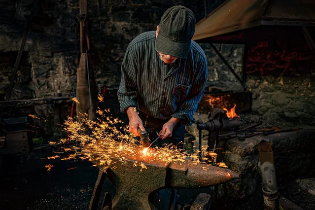 Sparks fly as a blacksmith forges steel on an anvil at the National Trust's Finch Foundry in Oakhampton, Devon on Saturday, November 19, 2022 to mark St Clement's Day, the patron saint for blacksmiths. (Photo by Ben Birchall/PA Wire)