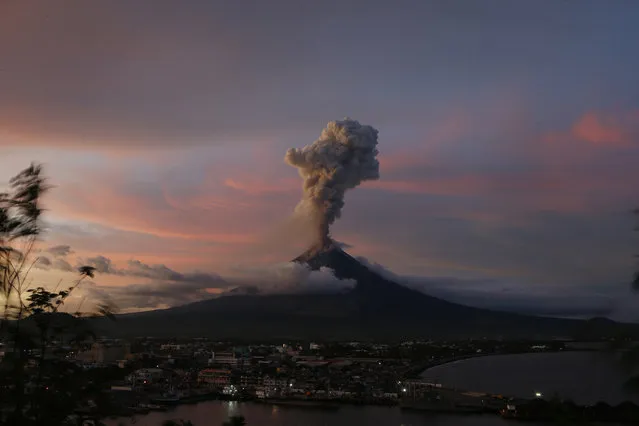 The Mayon volcano continues to erupt as the sun sets behind Legazpi city, Thursday, January 25, 2018 in Albay province, roughly 340 kilometers, (200 miles) southeast of Manila, Philippines. (Photo by Bullit Marquez/AP Photo)