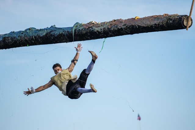A contestant falls from the greasy pole during the 98th annual St. Peter's Fiesta in Gloucester, Massachusetts, United States on June 27, 2025. (Photo by Joseph Prezioso/Anadolu via Getty Images)