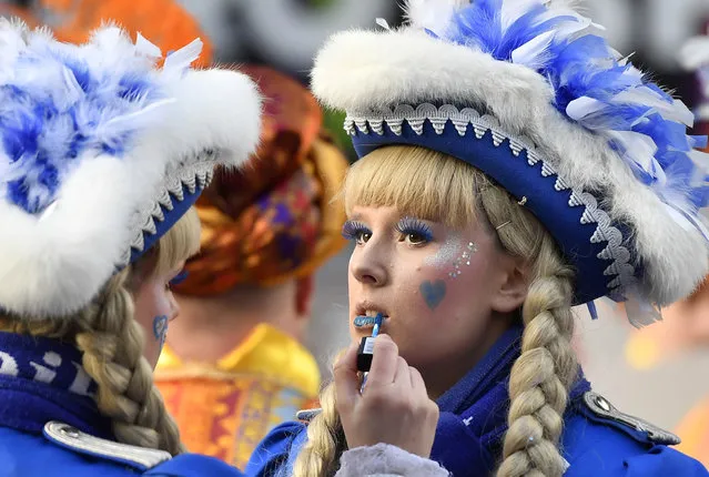 Carnivalists put on make up during the traditional Rose Monday parade in Duesseldorf, Germany, Shrove Monday, February 12, 2018. (Photo by Martin Meissner/AP Photo)
