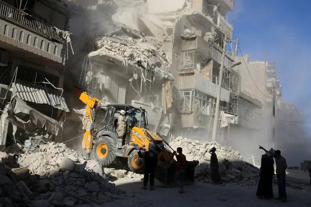 A front loader removes debris in a damaged site after airstrikes on the rebel held Tariq al-Bab neighbourhood of Aleppo, Syria September 24, 2016. (Photo by Abdalrhman Ismail/Reuters)