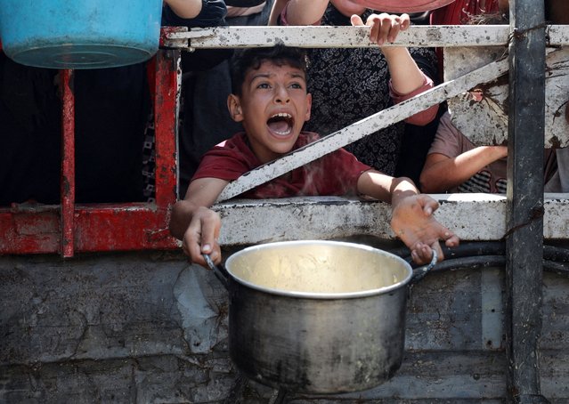 A Palestinian reacts as he waits to receive food from a charity kitchen, amid a hunger crisis, in Gaza City, on July 28, 2025. (Photo by Khamis Al-Rifi/Reuters)