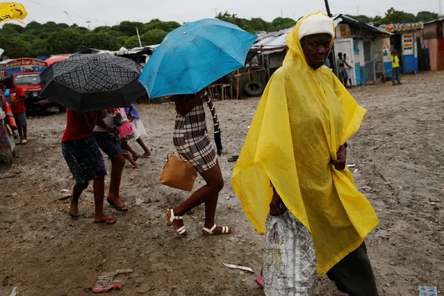 People walk down the street at a camp for displaced people while Hurricane Matthew approaches in Port-au-Prince, Haiti October 3, 2016. (Photo by Carlos Garcia Rawlins/Reuters)