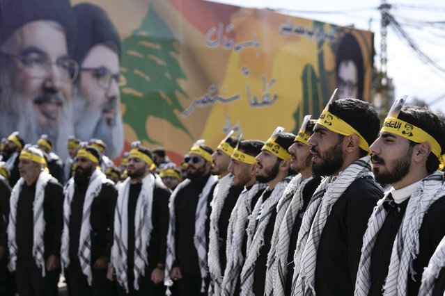 Backdropped by a poster featuring images of Lebanon's former Hezbollah leaders, Hassan Nasrallah and Hashem Safieddine, Hezbollah supporters chant slogans before during their funeral procession at Nasrallah's burial site in Beirut's southern suburbs, Lebanon, Sunday, February 23, 2025. (Photo by Bilal Hussein/AP Photo)