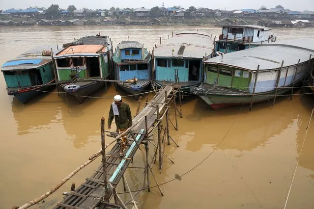 A muslim man walks across a bridge on his way to attend prayers on the Kahayan River in Palangkaraya, Central Kalimantan, Indonesia October 30, 2015. (Photo by Darren Whiteside/Reuters)