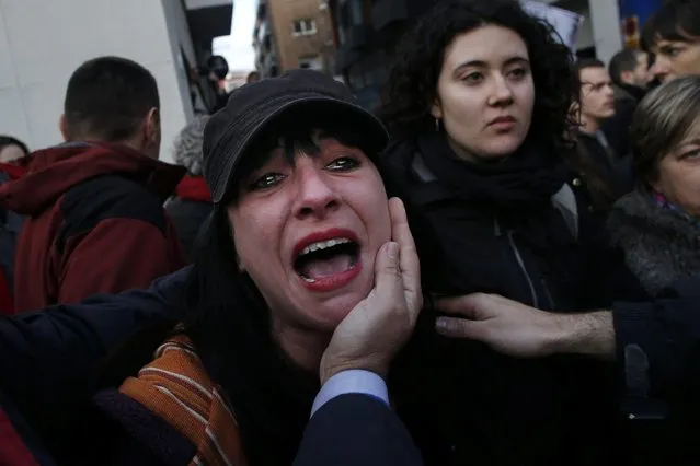 An anti-eviction activist cries and screams at Spanish policemen after having been pushed around during an “escrache” (denunciation) protest in Madrid April 5, 2013. Spanish protesters seeking to stop a wave of evictions have resorted to embarrassing politicians at their homes over harsh mortgage laws that have multiplied the pain of a property crash in the recession-hit country. Inspired by Latin American human rights campaigns from the 1990s, the “escraches” – Argentine slang for denunciation – have involved protesters posting flyers and shouting slogans on the doorsteps of a number of politicians over the past fortnight. (Photo by Susana Vera/Reuters)