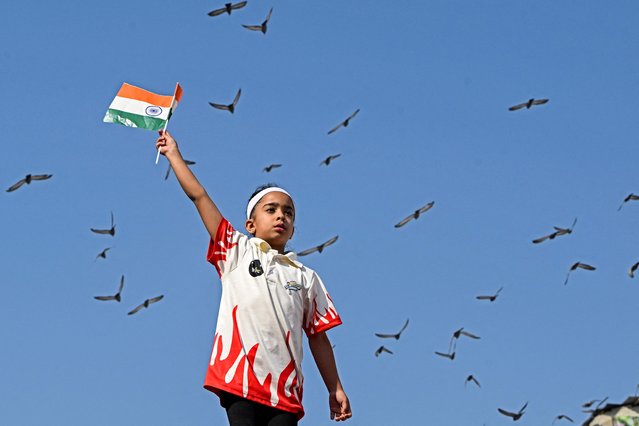 A Kashmiri child waves India's national flag during the High-Altitude CRPF (Central Reserve Police Force) Bike Expedition 2025 in Srinagar on September 23, 2025. (Photo by Tauseef Mustafa/AFP Photo)