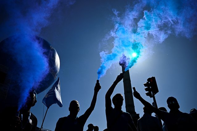 Protesters wave flags and brandish smoke flares in front of the July Column at Place de la Bastille in central Paris, on September 18, 2025, during a demonstration part of a day of nationwide strikes and protests called by unions over France's national budget. France is bracing for a day of nationwide protests on September 18, 2025, with a source close to the authorities saying some 800,000 people are expected to take to the streets. In a rare show of unity, trade unions have urged French people to strike in protest at the authorities' “horror show” draft budget designed to reduce France's ballooning debt. (Photo by Julien De Rosa/AFP Photo)