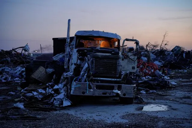 A semi truck is seen with its cabin lights left on at dawn in the town of Rolling Fork after thunderstorms spawning high straight-line winds and tornadoes ripped across the state, in Rolling Fork, Mississippi, U.S., March 26, 2023. (Photo by Cheney Orr/Reuters)