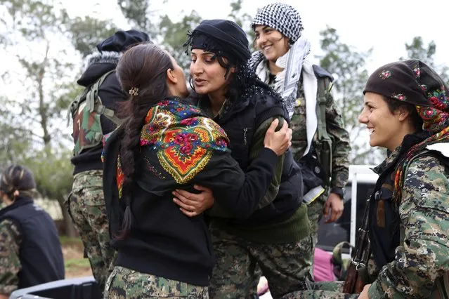 A Kurdish People's Protection Units (YPG) fighter hugs a fellow fighter in a YPG military base east of Qamishli, Syria, before heading to Jazaa and Tal Kojar frontlines December 19, 2014. (Photo by Massoud Mohammed/Reuters)