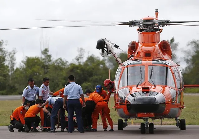 Indonesian Search and Rescue crews unload one of two bodies of AirAsia passengers recovered from the sea, at the airport in Pangkalan Bun, Central Kalimantan, December 31, 2014. (Photo by Darren Whiteside/Reuters)