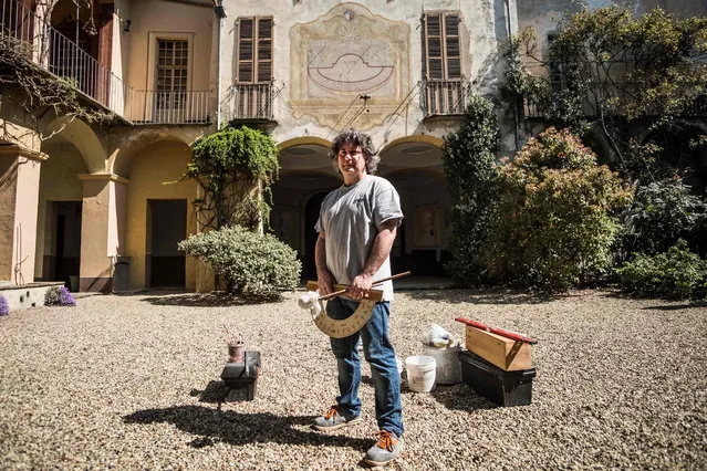 Fabio Garnero, one of the last gnomonist in Italy, poses for a picture in a Renaissance' s mansion where he restores an ancient sundial on April 17, 2018 in Saluzzo, near Turin. Fabio Garnero is one of the last gnomonist in Italy than uses traditional techniques to calculate and draw the sundial on the buildings. He spends a lot of time to catalogue and restore ancient sundials in Italy and in Europe. (Photo by Marco Bertorello/AFP Photo)