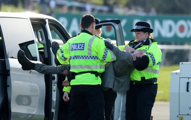 Police detain an animal rights activist at the annual Grand National meeting in Aintree, England on April 16, 2023. (Photo by Phil Noble/Reuters)