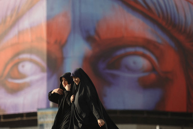 Iranian women walk past an anti-U.S. billboard on a street in Tehran, Iran, on November 5, 2025. (Photo by Majid Asgaripour/WANA (West Asia News Agency) via Reuters)
