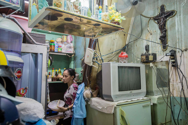 Nguyen Thi Kim Ngoc prepares to cook in her 6.7- square- metre home in Ho Chi Minh City on May 3, 2018. (Photo by Thanh Nguyen/AFP Photo)