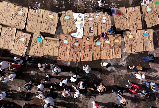 In this aerial view relatives of missing persons place human silhouette posters with portraits of their loved ones during the march on the International Day of the Disappeared in Guadalajara, Jalisco state, Mexico, on August 30, 2024. (Photo by Ulises Ruiz/AFP Photo)