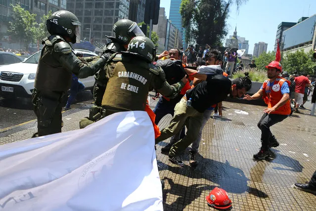 Riot policemen attempt to detain demonstrators during a strike against the national pension system in Santiago, Chile, November 4, 2016. (Photo by Ivan Alvarado/Reuters)