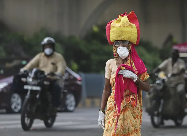 A woman wearing a face mask walks on a street in Hyderabad, India, Friday, July 17, 2020. India crossed 1 million coronavirus cases on Friday, third only to the United States and Brazil, prompting concerns about its readiness to confront an inevitable surge that could overwhelm hospitals and test the country's feeble health care system. (Photo by Mahesh Kumar A./AP Photo)