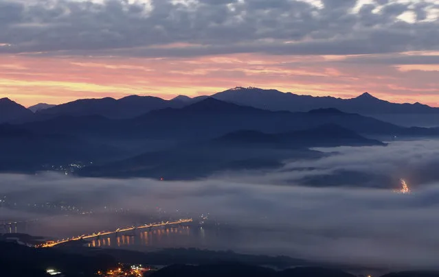Lights on the roads and a country village are seen under a “sea of clouds” on the South Han River and North Han River, as it is seen from Mount Yebin in Namyangju, Gyeonggi-do, South Korea, 15 September 2015. (Photo by Jeon Heon-Kyun/EPA)