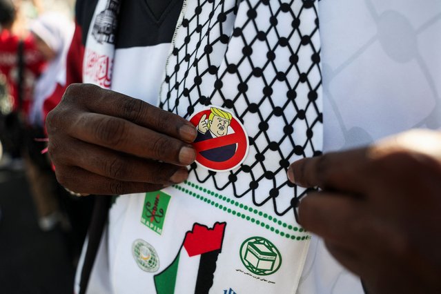 A pin badge depicting U.S. President Donald Trump on the keffiyeh of a demonstrator during a protest against U.S. President Trump's attendance at the 47th ASEAN Summit, at Dataran Merdeka, Kuala Lumpur, Malaysia on October 26, 2025. (Photo by Edgar Su/Reuters)