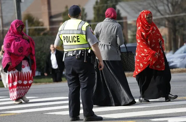 A Fairfax County police officer controls traffic as women make their way to the Dar Al-Hijrah Islamic Center in Falls Church, Virginia  just outside of Washington December 11, 2015. Security concerns at mosques around the United States have been heightened in the wake of the Dec. 2 shooting rampage in San Bernardino, California. (Photo by Kevin Lamarque/Reuters)