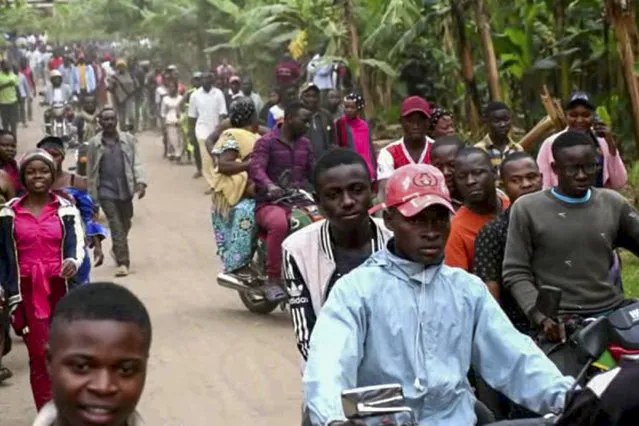 In this image made from video, people make their way towards the Lhubiriha Secondary School following an attack on the school near the border with Congo, in Mpondwe, Uganda, Saturday, June 17, 2023. Ugandan authorities recovered the bodies of dozens of people including students who were burned, shot or hacked to death after suspected rebels attacked the school, the local mayor said Saturday. (Photo by AP Photo/Stringer)