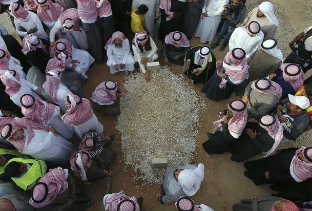 Mourners gather around the grave of Saudi King Abdullah following his burial in Riyadh January 23, 2015. Saudi King Salman pledged on Friday to maintain existing energy and foreign policies then quickly moved to appoint younger men as his heirs, settling the succession for years to come by naming a deputy crown prince from his dynasty's next generation. (Photo by Reuters/Stringer)