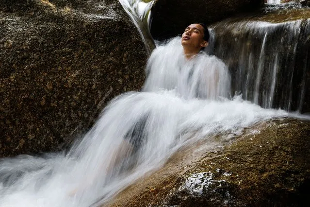 An image made with a slow shutter speed shows a man cooling off in a small waterfall of the Kalumpang river during a hot day with up to 33 degrees Celsius, in Tanjung Malim, Malaysia, 02 June 2023. Earlier in May 2023 Malaysia's Deputy Prime Minister Ahmad Zahid Hamidi had said that “there was not yet a need for Malaysia to declare a heatwave Emergency, but the government would review this if temperatures reached 40 degrees Celsius”. (Photo by Fazry Ismail/EPA/EFE/Rex Features/Shutterstock)