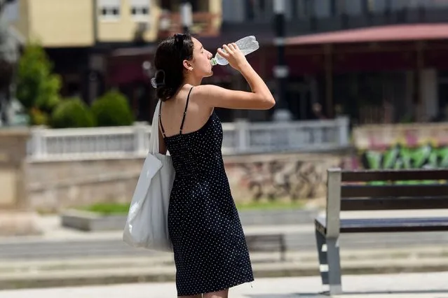 A woman drinks in Skopje, on July 18, 2023, as Europe braces for record-smashing heat. Europe braced for record-smashing heat on July 18, 2023 as withering heatwaves across the globe showed no signs of easing, and ongoing wildfires in Greece and the Canary Islands threatened homes while worsening air quality. (Photo by Robert Atanasovski/AFP Photo)