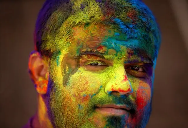 A man daubed in colours looks on during Holi celebrations, amidst the spread of the coronavirus disease (COVID-19), in Ahmedabad, India, March 29, 2021. (Photo by Amit Dave/Reuters)