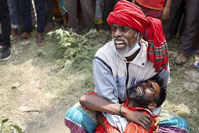 Relatives cry as rescuers recover bodies after a ferry sank Sunday night after being hit by a cargo vessel in the Shitalakkhya River in Narayanganj district, outside Dhaka, Bangladesh, Monday, April 5, 2021. (Photo by Mushfiqul Alam/AP Photo)