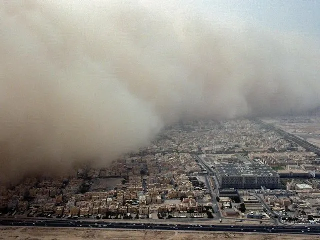 This picture taken on May 23, 2022 shows an aerial view of a massive dust storm advancing into Kuwait City. (Photo by Yasser Al-Zayyat/AFP Photo)