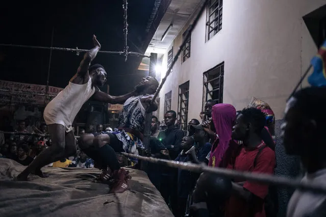 Wrestlers face off in a ring set up in a schoolyard in Selemenbao district in Kinshasa, on July 29, 2023. In poor neighbourhoods of the Democratic Republic of Congo's capital Kinshasa, bouts of voodoo wrestling – an over-the-top combat sport featuring traditional magic – serve as popular entertainment. (Photo by Alexis Huguet/AFP Photo)