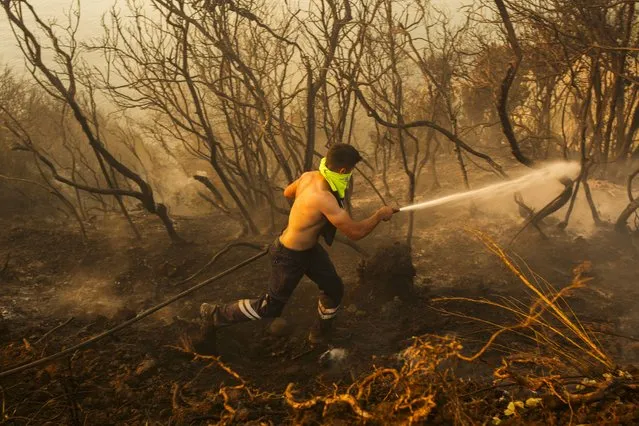 A Turkish firefighter works to extinguish a forest wildfire in Beykoz, outskirts Istanbul, Turkey, Wednesday, July 26, 2023. Water-dropping planes, helicopters and firefighters were also deployed to fight a blaze that broke out Wednesday at a forest near the district of Beykoz, in Istanbul, where temperatures reached 43 C. (Photo by Emrah Gurel/AP Photo)