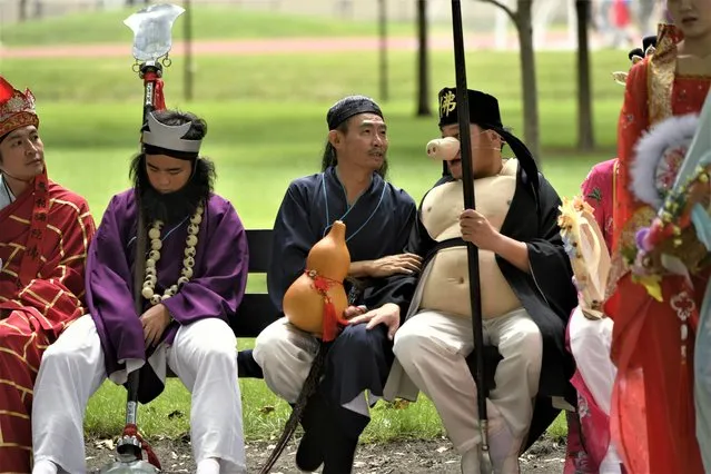 Members of the Tai Ji Men Qigong Academy talk before the Parliament of World Religion Parade of Faiths, Sunday, August 13, 2023, in Chicago. (Photo by Paul Beaty/AP Photo)