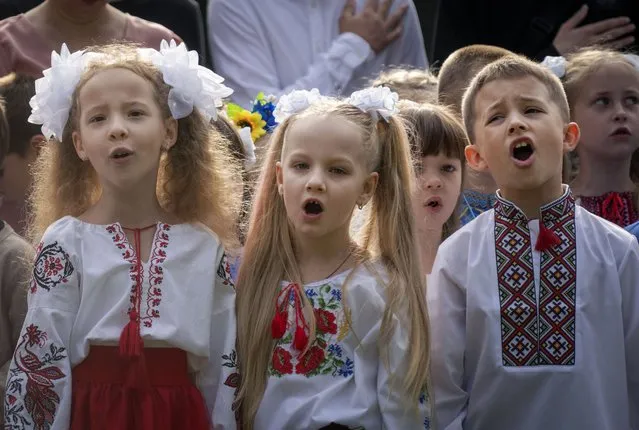 School children sing Ukraine's national anthem as they attend a ceremony of the first day in school in Bucha, Ukraine, Friday, September 1, 2023. Ukraine marks Sept. 1 as Knowledge Day, as a traditional launch of the academic year. (Photo by Efrem Lukatsky/AP Photo)