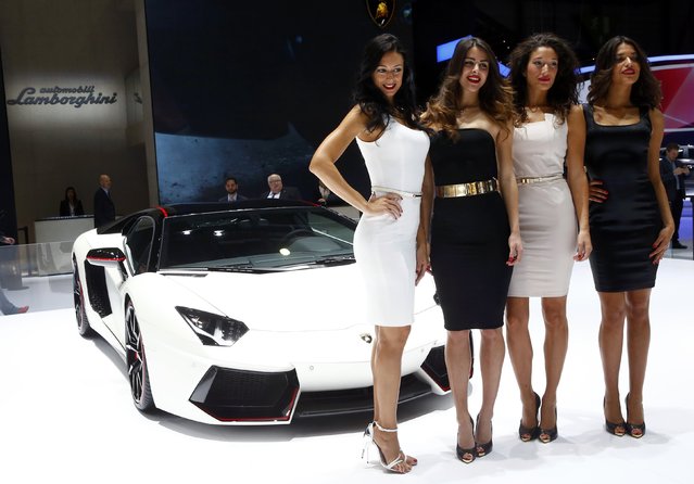 Models pose in front of a Lamborghini Aventador LP 700-4 during the second press day ahead of the 85th International Motor Show in Geneva March 4, 2015.  REUTERS/Arnd Wiegmann   