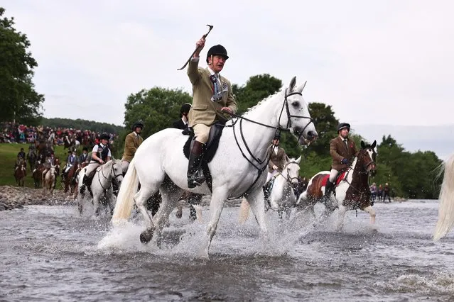 Riders ford the river Ettrick, as they take part in the town's Common Riding one of the oldest Borders festivals on June 17, 2022 in Selkirk, Scotland. In the centuries-old tradition, a cavalcade of horsemen and women ride the town's boundaries, echoing a practice from the late Middle Ages when there were frequent raids on the Anglo-Scottish border. (Photo by Jeff J. Mitchell/Getty Images)