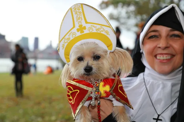 Susan from New York City holds her dog Tasha dressed a the the Pope during the 28th Annual Tompkins Square Halloween Dog Parade at East River Park Amphitheater in New York on October 28, 2018. (Photo by Gordon Donovan/Yahoo News)