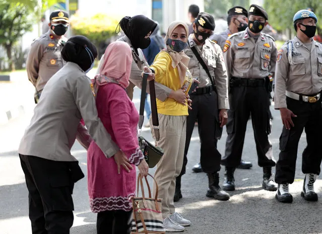 Police search visitors entering the East Jakarta District Court where the sentencing hearing of firebrand cleric Rizieq Shihab is being held in Jakarta, Indonesia, Thursday, May 27, 2021. (Photo by Dita Alangkara/AP Photo)