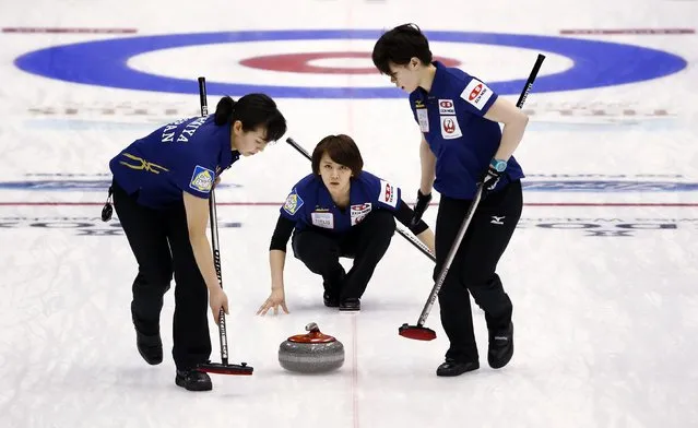 Japan's third Sayaka Yoshimura (C) directs her team-mates Anna Ohmiya (L) and Kaho Onodera as they sweep during their curling round robin game against Finland at the World Women's Curling Championship in Sapporo March 16, 2015. (Photo by Thomas Peter/Reuters)