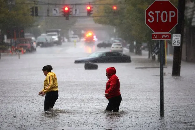 Residents walk through floodwaters during a heavy rain storm in the New York City suburb of Mamaroneck in Westchester County, New York, U.S., September 29, 2023. (Photo by Mike Segar/Reuters)