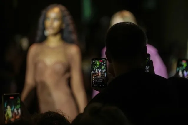 Guests use their cell phones to record the Roberto Cavalli women's Spring Summer 2024 collection presented in Milan, Italy, Wednesday, September 20, 2023. (Photo by Luca Bruno/AP Photo)