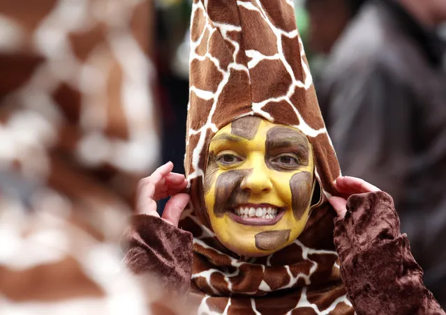 A woman wearing a  giraffe costume  attends carnival celebrations in Duesseldorf, Germany, Sunday February 7, 2016. (Photo by Roland Weihrauch/DPA via AP Photo)