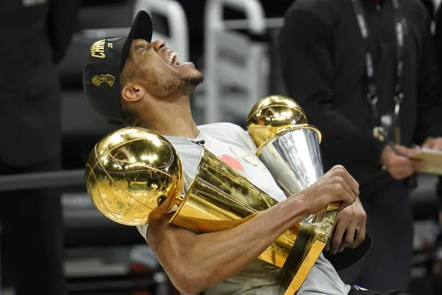 Milwaukee Bucks forward Giannis Antetokounmpo reacts while holding the NBA Championship trophy, left, and Most Valuable Player trophy after defeating the Phoenix Suns in Game 6 of basketball's NBA Finals in Milwaukee, Tuesday, July 20, 2021. The Bucks won 105-98. (Photo by Paul Sancya/AP Photo)