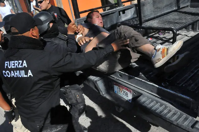 Policemen detain a demonstrator during a protest against the rising prices of gasoline enforced by the Mexican government, in Monclova, in Coahuila state, Mexico, January 5, 2017. (Photo by Fidencio Alonso/Reuters/Courtesy of Zocalo de Monclova)