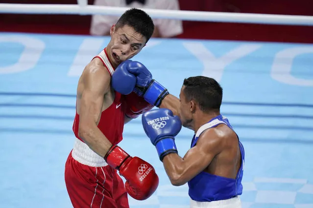 Kazakhstan's Saken Bibossinov, left, get hit with a punch by Puerto Rico's Yankiel Rivera Figueroa during their men's flyweight 52-kg boxing match at the 2020 Summer Olympics, Monday, July 26, 2021, in Tokyo, Japan. (Photo by Frank Franklin II/AP Photo)