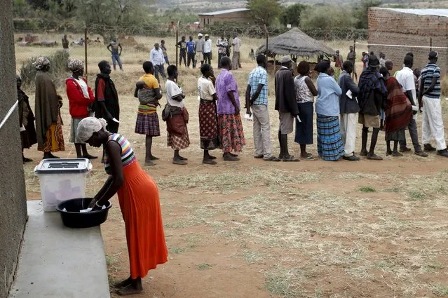 A Karamojong tribeswoman casts her ballot at a polling station during the presidential elections in a village near Kaabong in Karamoja region, Uganda, February 18, 2016. (Photo by Goran Tomasevic/Reuters)