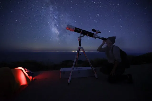 A woman looks through a telescope during the annual Perseid meteor shower on the island of Lastovo, Croatia on August 12, 2023. (Photo by Antonio Bronic/Reuters)