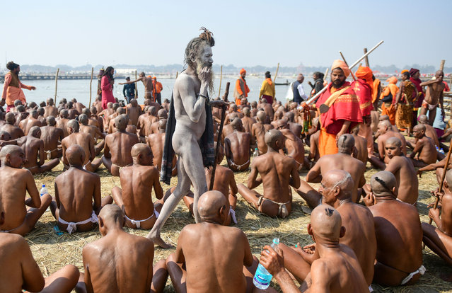 Newly-initiated “Naga Sadhus” (Hindu holy men) sit as they perform rituals on the banks of the Ganges River during the Kumbh Mela festival, in Allahabad on February 1, 2019. During every Kumbh Mela, the diksha, a ritual of initiation by a guru takes place for new members. (Photo by Sanjay Kanojia/AFP Photo)